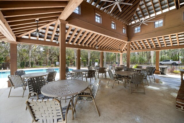 view of patio / terrace featuring fence, ceiling fan, and a community pool