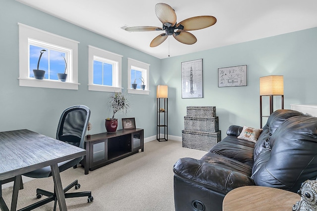 living area featuring light carpet, a desk, ceiling fan, and baseboards