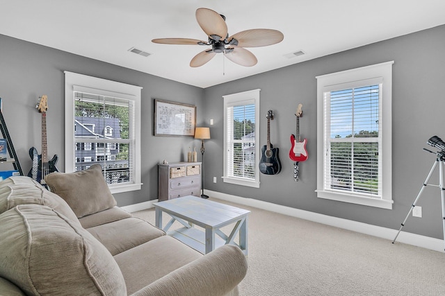 carpeted living area with baseboards, healthy amount of natural light, and ceiling fan