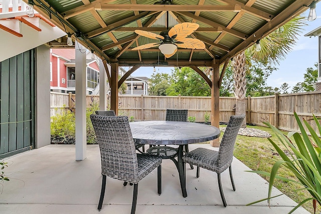view of patio / terrace with a gazebo, a fenced backyard, ceiling fan, and outdoor dining area