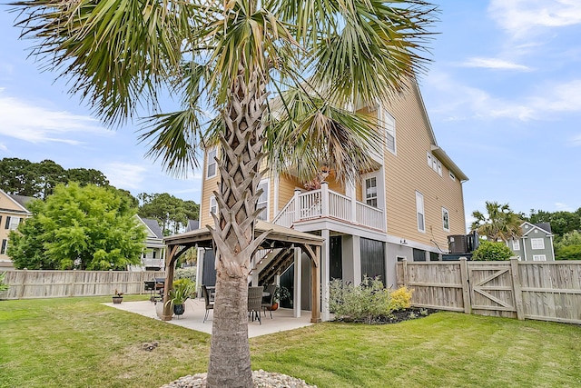 rear view of property featuring a gazebo, a gate, and a patio area