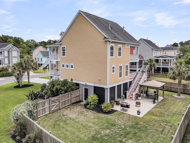 rear view of property featuring a gazebo, stairs, a residential view, and a patio area