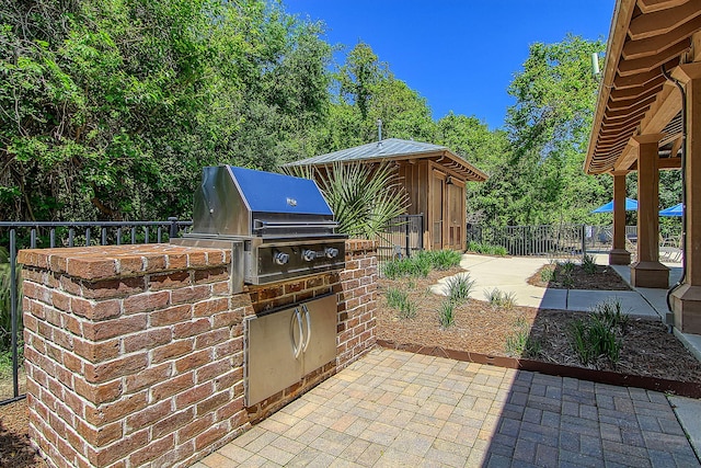 view of patio with fence, a grill, and an outdoor kitchen
