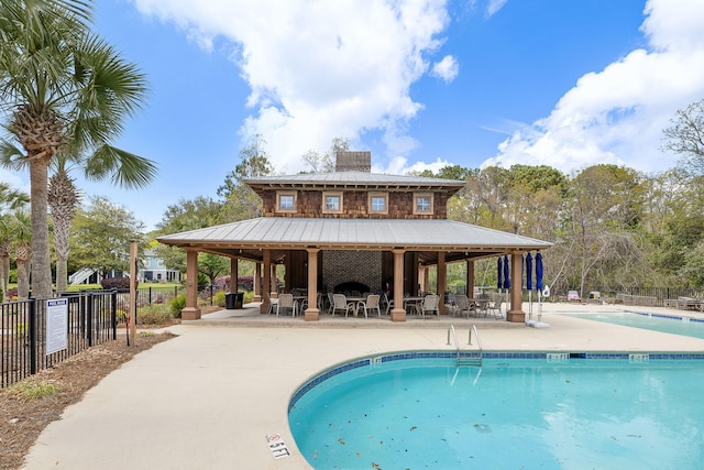 community pool with fence, a patio area, a gazebo, and outdoor dining area