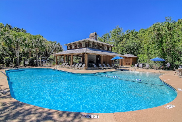 community pool featuring a patio, a gazebo, and fence
