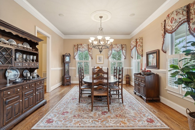 dining space with ornamental molding, light wood-type flooring, and a healthy amount of sunlight