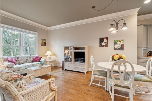 living area featuring ornamental molding, light wood-type flooring, baseboards, and an inviting chandelier