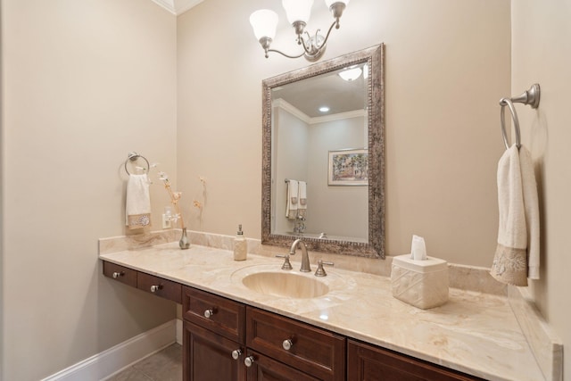 bathroom with tile patterned flooring, vanity, baseboards, ornamental molding, and an inviting chandelier