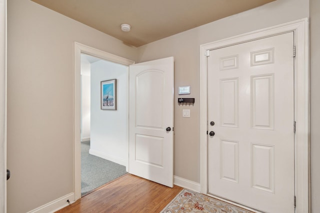 foyer entrance featuring baseboards and wood finished floors