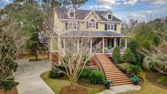 view of front of property featuring covered porch and stairs