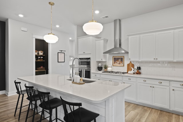 109 Medford St, Summerville, SC 29486 - kitchen featuring wall chimney exhaust hood, a sink, stainless steel appliances, a kitchen island with sink, and white cabinets