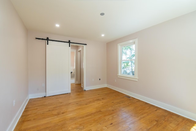 708 S Laurel St, Summerville, SC 29483 - unfurnished room featuring recessed lighting, a barn door, light wood-style flooring, and baseboards