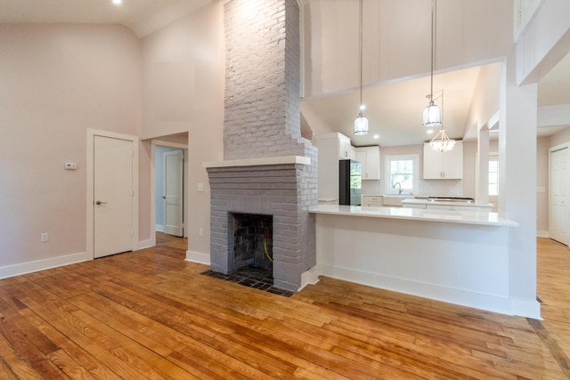 708 S Laurel St, Summerville, SC 29483 - kitchen featuring high vaulted ceiling, light wood-style flooring, white cabinetry, and freestanding refrigerator