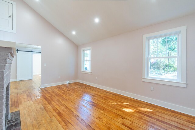 708 S Laurel St, Summerville, SC 29483 - unfurnished living room with baseboards, a barn door, recessed lighting, vaulted ceiling, and light wood-style flooring