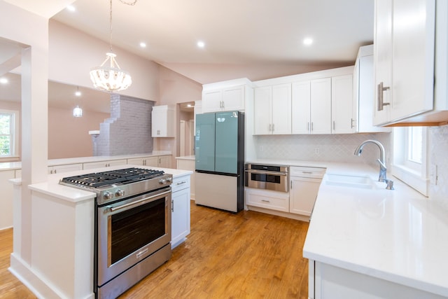 708 S Laurel St, Summerville, SC 29483 - kitchen featuring appliances with stainless steel finishes, vaulted ceiling, light wood-style flooring, decorative backsplash, and a sink