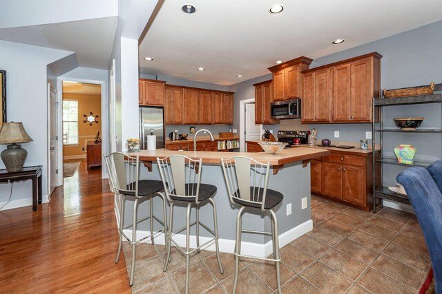 477 Commonwealth Rd, Mount Pleasant, SC 29466 - kitchen with appliances with stainless steel finishes, brown cabinets, recessed lighting, light countertops, and an island with sink