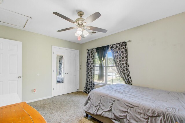 bedroom featuring ceiling fan, a closet, carpet flooring, attic access, and baseboards