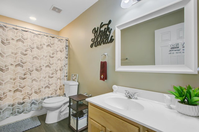 bathroom featuring toilet, wood finished floors, vanity, and visible vents