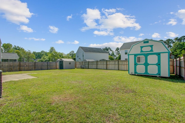 view of yard featuring a storage shed, a fenced backyard, an outdoor structure, and a patio area