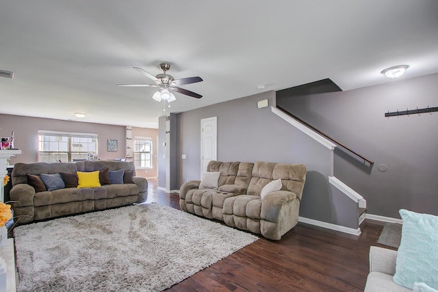 living room with baseboards, a ceiling fan, visible vents, and stairs