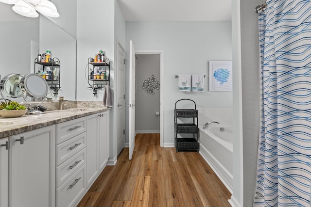 bathroom featuring vanity, hardwood / wood-style floors, and plus walk in shower