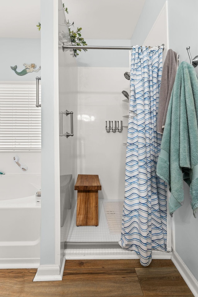 bathroom featuring wood-type flooring and plus walk in shower