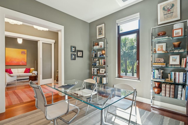 dining space with wood-type flooring and french doors