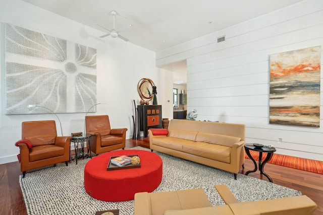 living room featuring wood walls, ceiling fan, and hardwood / wood-style flooring