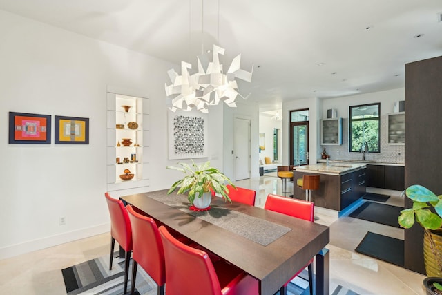 dining space featuring sink and a notable chandelier