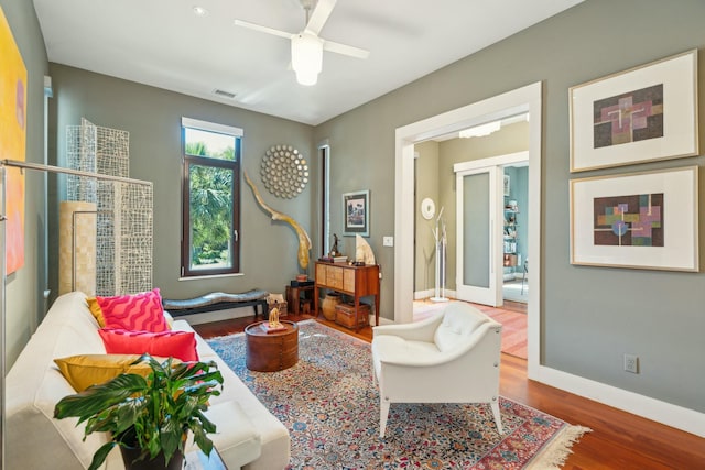 living area with french doors, hardwood / wood-style flooring, and ceiling fan