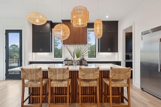 231 Bayview Dr, Mount Pleasant, SC 29464 - kitchen with appliances with stainless steel finishes, backsplash, light countertops, light wood-style floors, and a center island with sink