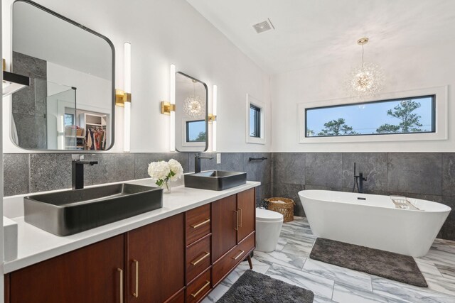 231 Bayview Dr, Mount Pleasant, SC 29464 - bathroom featuring tile walls, double vanity, a freestanding tub, tiled shower, and a chandelier