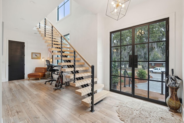 231 Bayview Dr, Mount Pleasant, SC 29464 - entrance foyer with stairs, french doors, wood-type flooring, a chandelier, and a towering ceiling