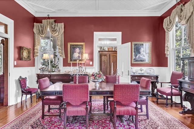 dining space with plenty of natural light, wood finished floors, and wainscoting