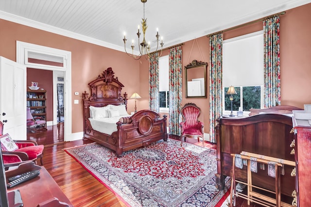 bedroom featuring an inviting chandelier, crown molding, baseboards, and wood finished floors