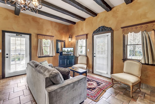 living room with a notable chandelier and beam ceiling