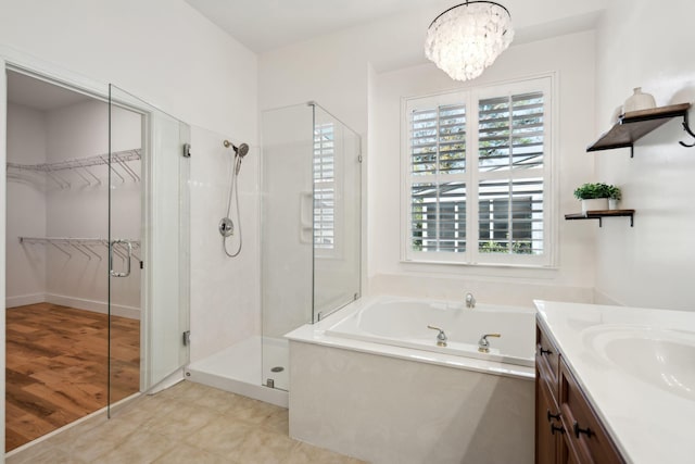 bathroom with vanity, a notable chandelier, and plus walk in shower