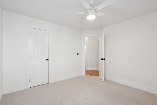 unfurnished room featuring light colored carpet and ceiling fan