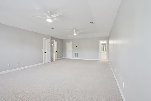 spare room with light colored carpet, ceiling fan, and a tray ceiling