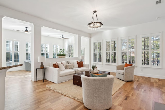 sunroom with a healthy amount of sunlight and ceiling fan with notable chandelier