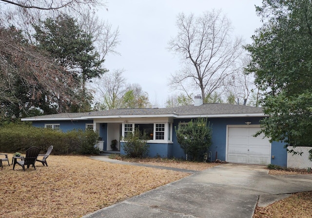 single story home featuring a garage and a fire pit