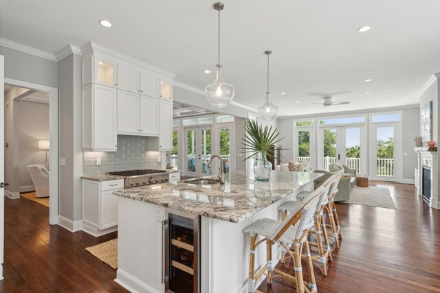 591 Island Walk E, Mount Pleasant, SC 29464 - kitchen featuring beverage cooler, crown molding, recessed lighting, white cabinetry, and decorative backsplash