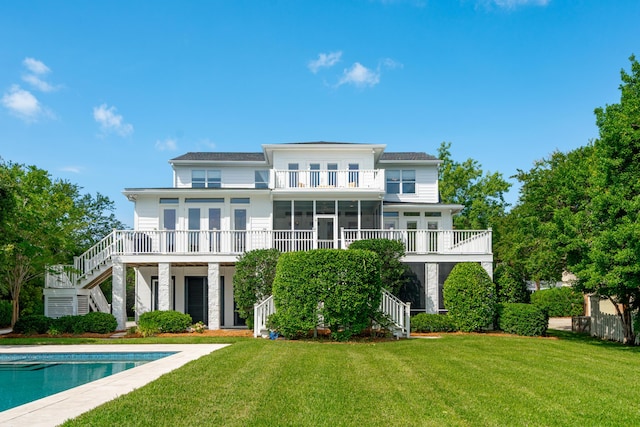 591 Island Walk E, Mount Pleasant, SC 29464 - rear view of house featuring stairs, a yard, a sunroom, a balcony, and an outdoor pool