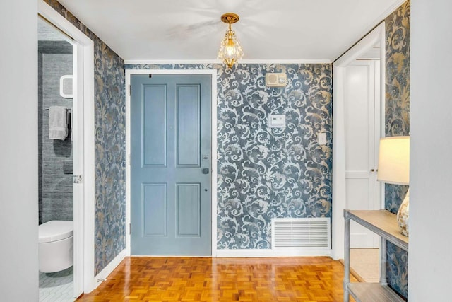 entryway with wallpapered walls, baseboards, and visible vents