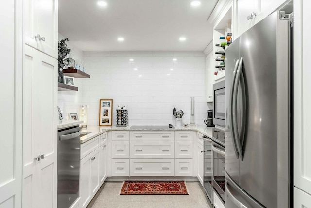 kitchen featuring appliances with stainless steel finishes, white cabinetry, light stone counters, and open shelves