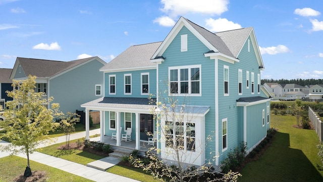 view of front facade featuring covered porch and a front yard