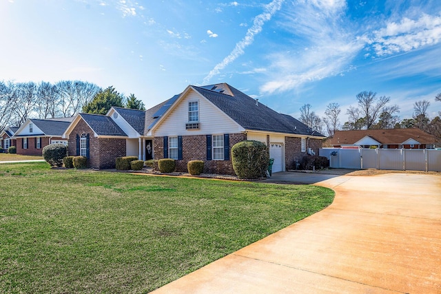 view of front of home with a garage, brick siding, concrete driveway, a gate, and a front yard