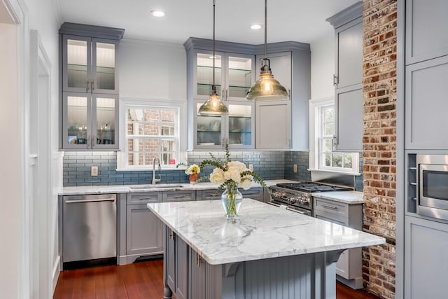 kitchen featuring tasteful backsplash, appliances with stainless steel finishes, and gray cabinetry