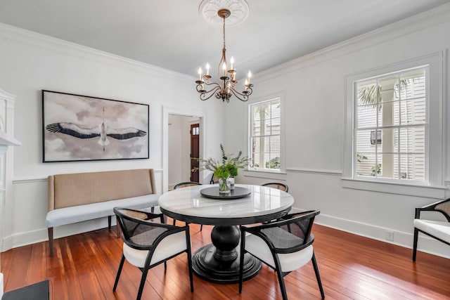 dining room featuring baseboards, hardwood / wood-style floors, an inviting chandelier, and crown molding