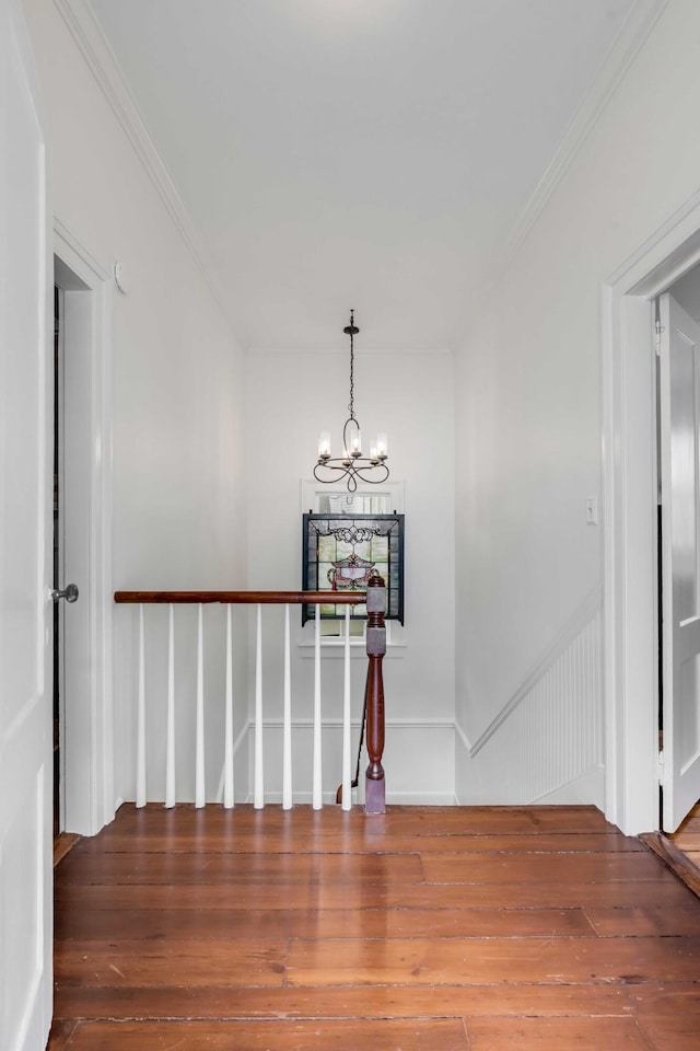 hall featuring a chandelier, crown molding, and wood finished floors